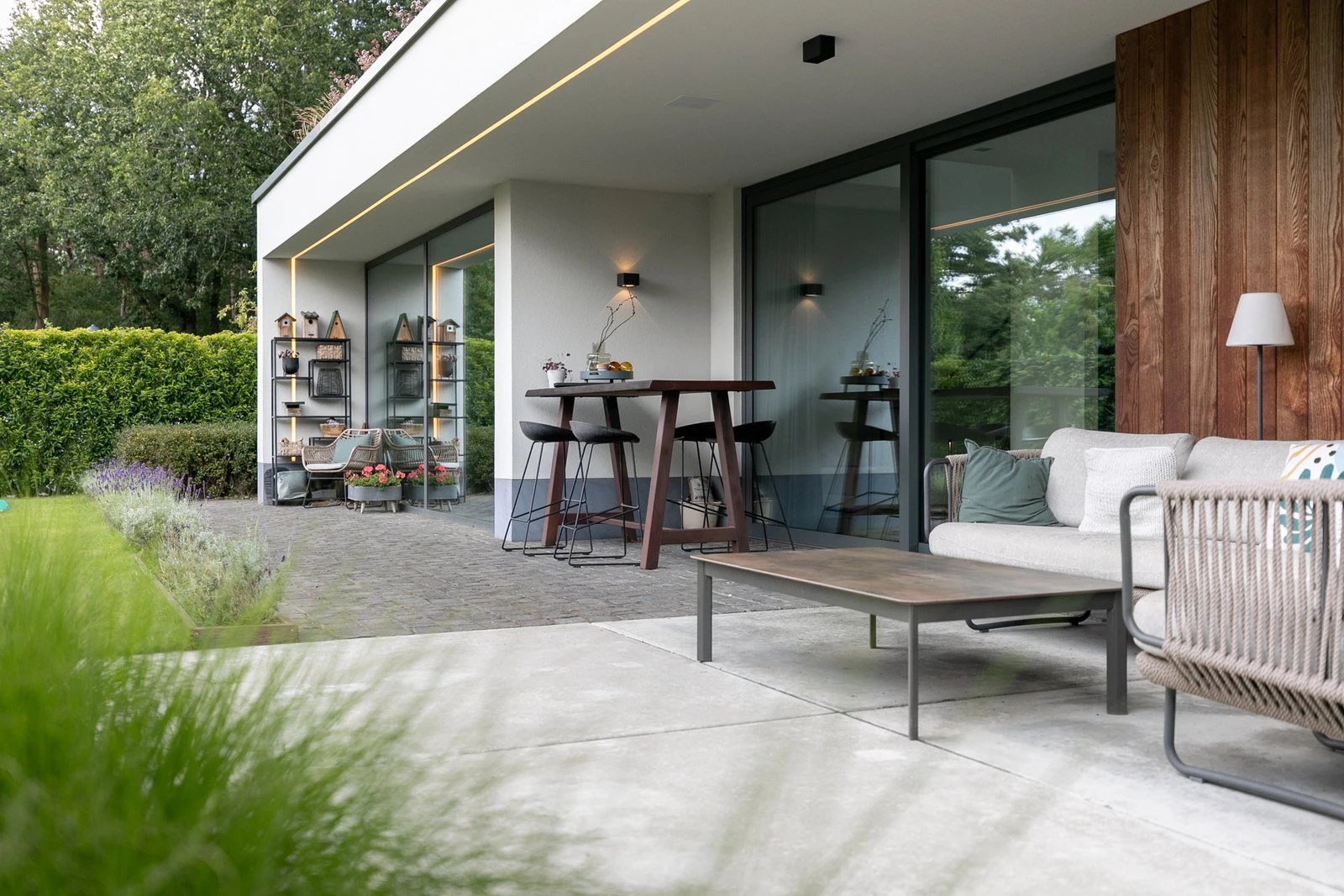 Terras aan een woning met plat dak en houten gevelbekleding