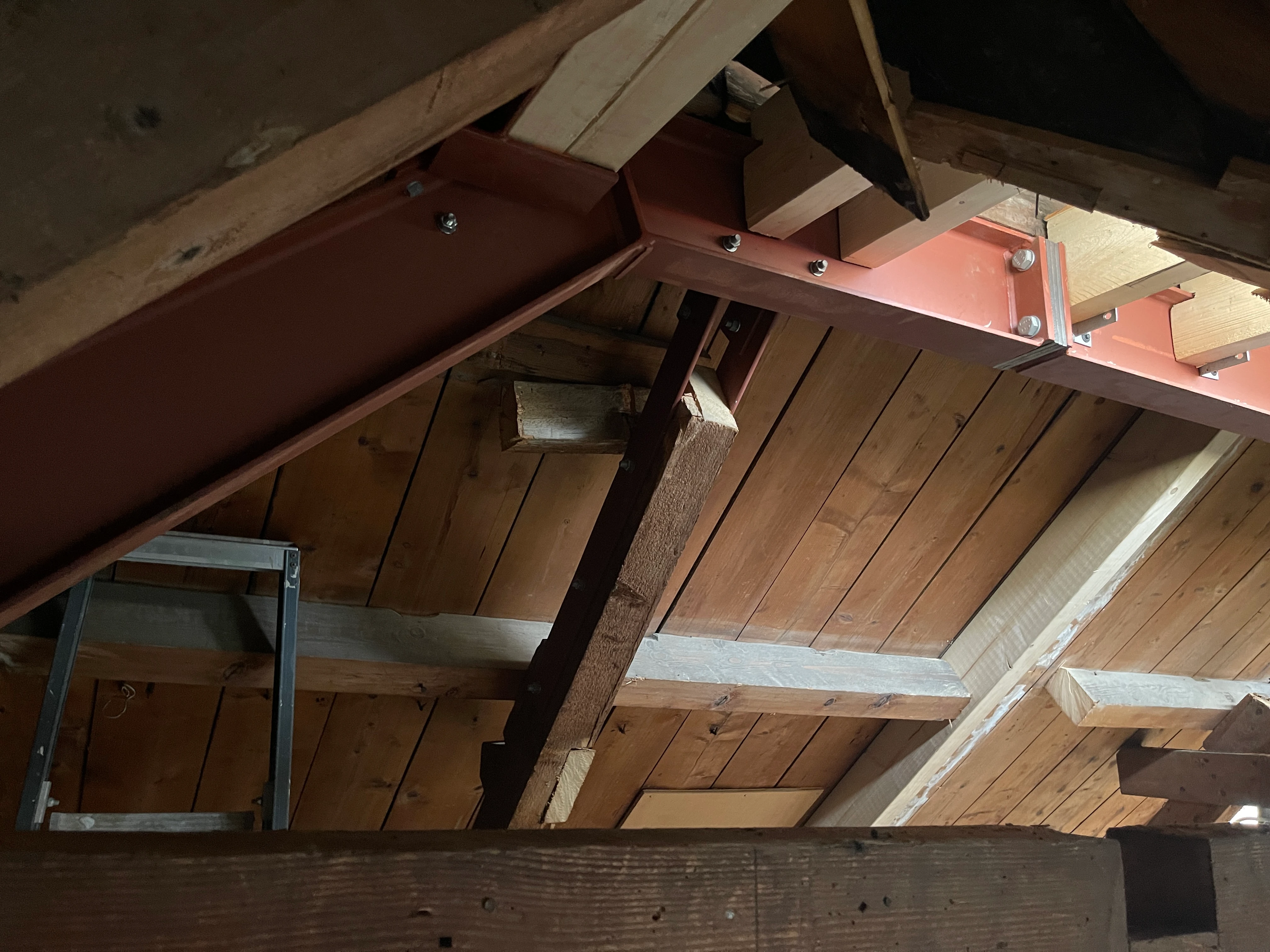 Stalen portaal onder de kap, met bouten verbonden aan de bestaande houten gordingen