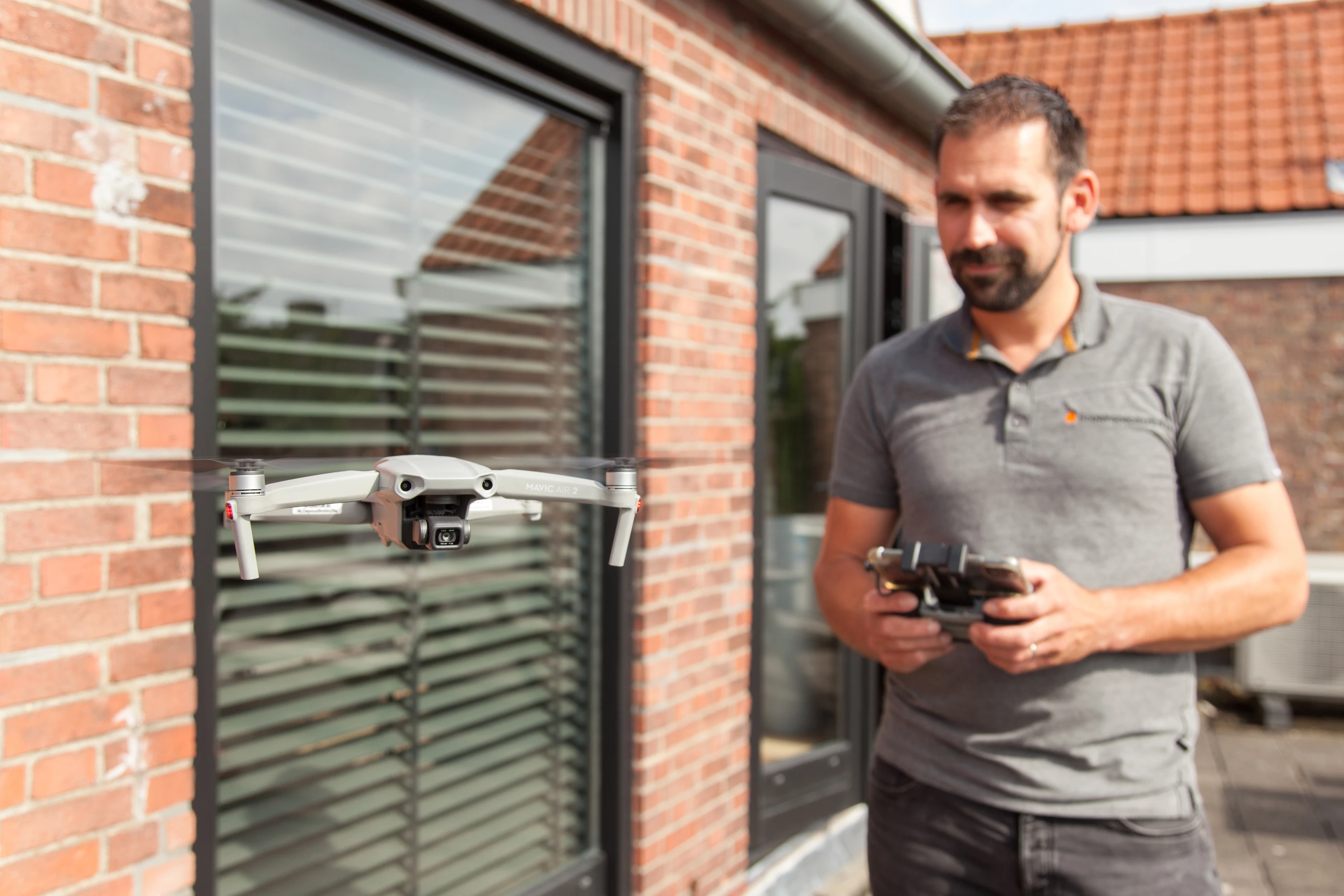 Collega laat een drone opstijgen langs de gevel van een woning