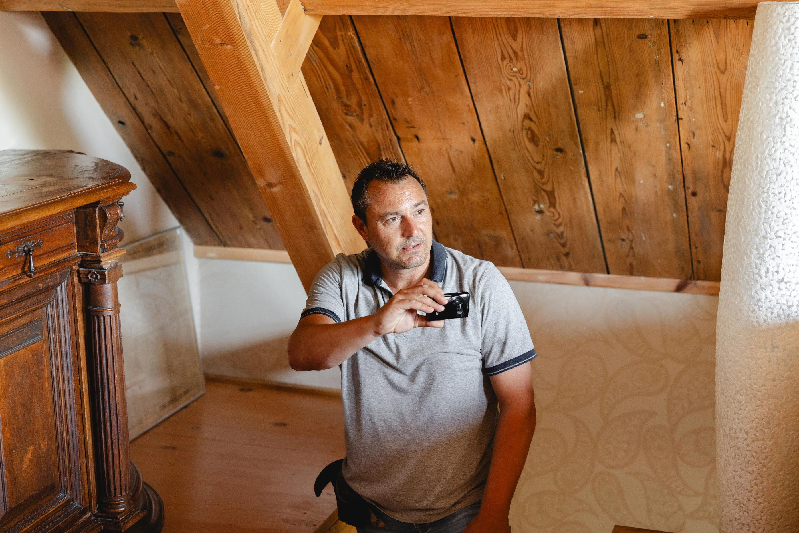 Inspecteur op een zolder onder een oude houten kapconstructie